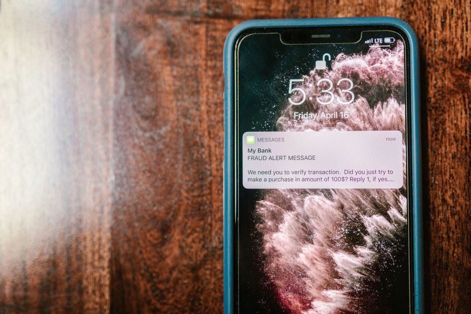 Pengguna memegang ponsel dengan layar aktif yang menampilkan notifikasi masuk