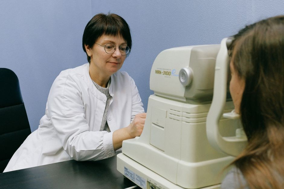 Dokter spesialis mata memeriksa kornea pasien menggunakan mikroskop slit lamp di klinik