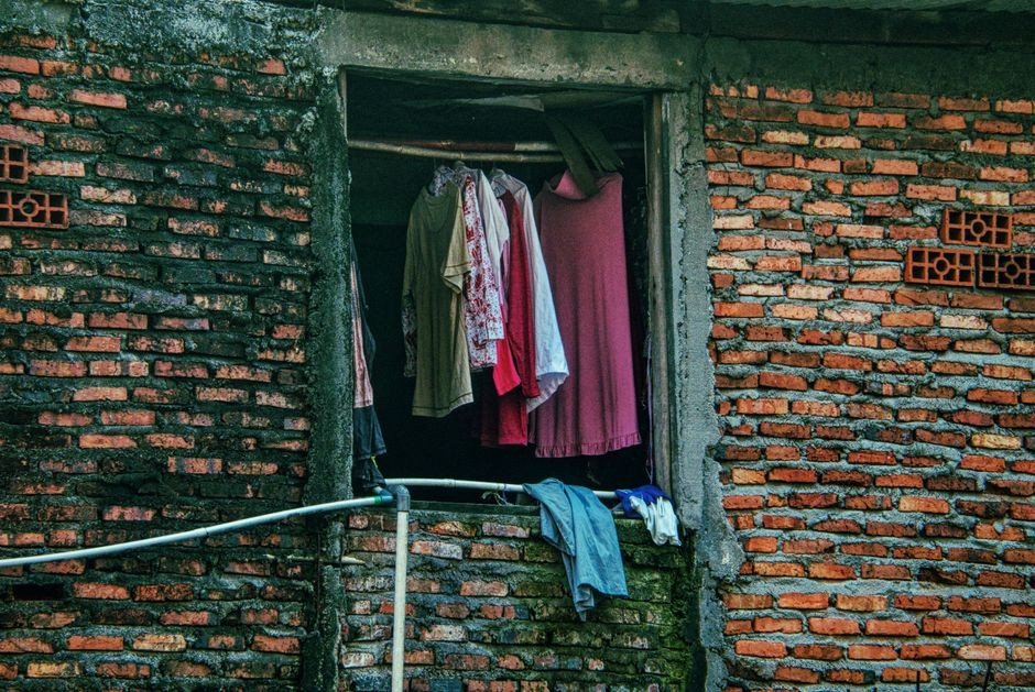 Ilustrasi pakaian basah dijemur di gantungan baju dalam ruangan tertutup