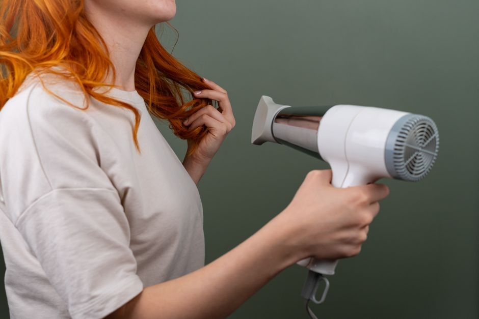 Alat pengering rambut hair dryer menyemburkan aliran udara panas