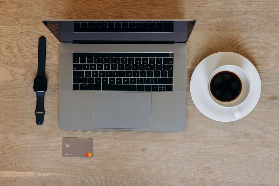 Ilustrasi laptop dan perangkat ponsel modern tersambung pengisi daya USB-C di atas meja kerja