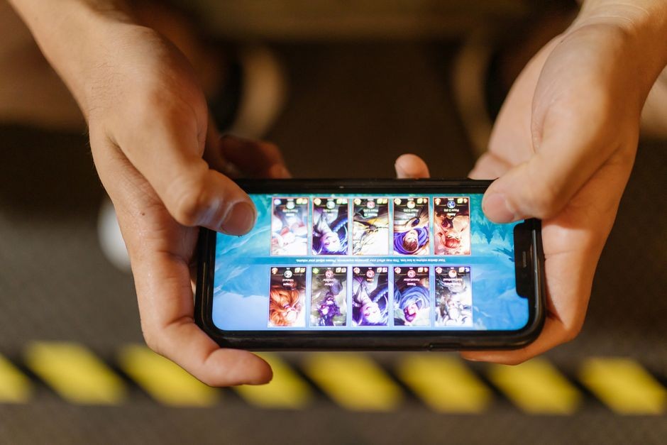 Seseorang sedang bermain game seluler di ponsel pintar yang memicu lonjakan suhu prosesor