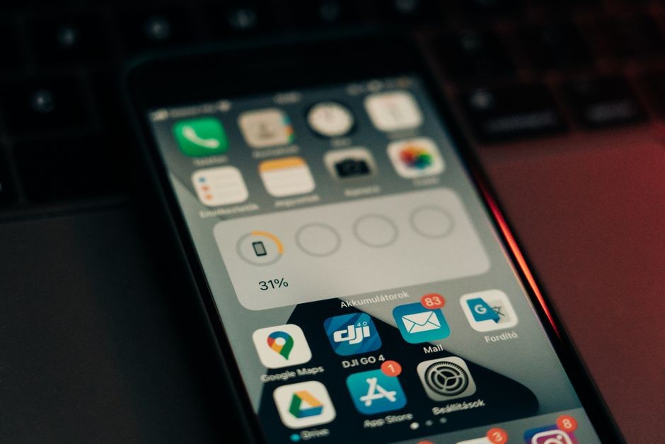 Sebuah smartphone dengan berbagai aplikasi di layarnya diletakkan di atas keyboard, menunjukkan level baterai 31 %.