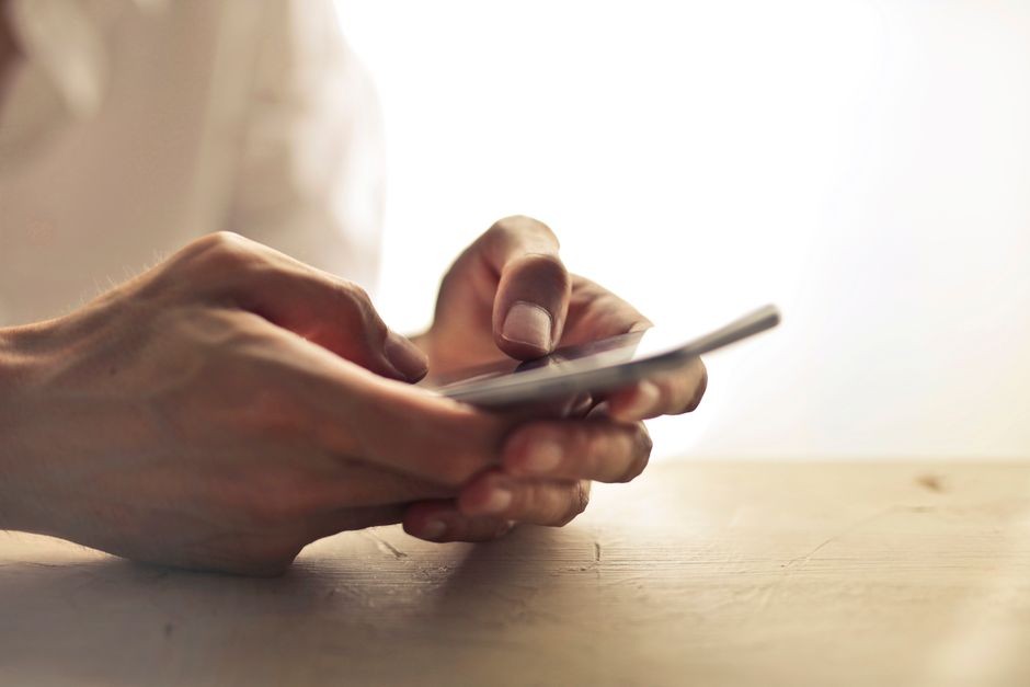 Seseorang melihat notifikasi pesan singkat di layar ponsel pintar