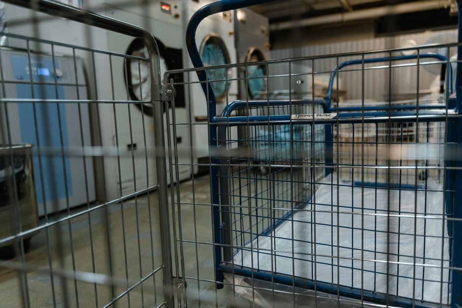 Tumpukan pakaian kotor dan mesin cuci di ruangan laundry rumah