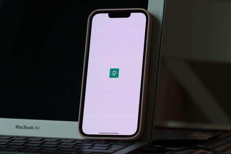 Tampilan jari tangan sedang mengutak-atik menu pengaturan data dan penyimpanan pada layar sentuh smartphone