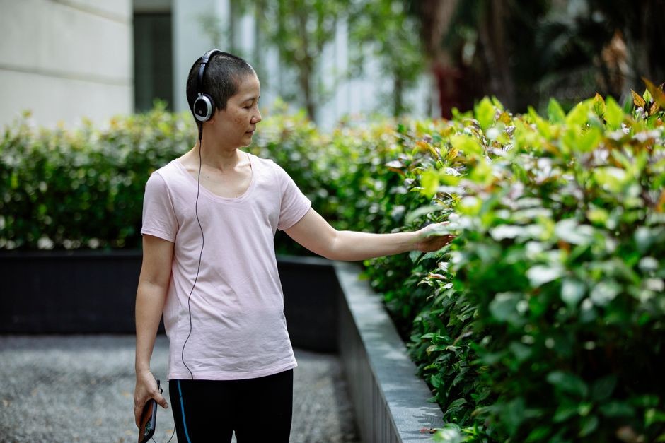 Seseorang sedang mengenakan headphone bone conduction saat berolahraga di luar ruangan