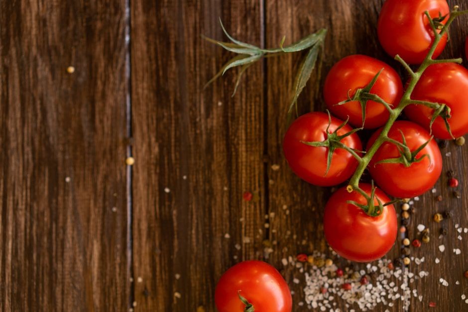Deretan tomat merah segar ranum yang disimpan di atas meja dapur