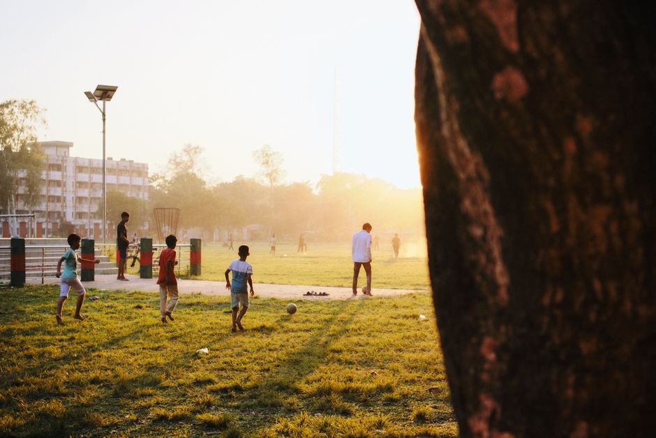 Anak-anak menikmati permainan sepak bola di taman yang disinari matahari di Kurigram, Bangladesh.