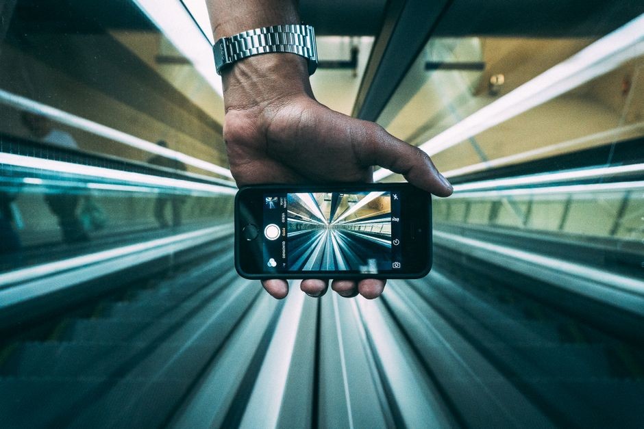 Seseorang memotret pemandangan jarak jauh dengan kamera smartphone berfitur zoom tinggi