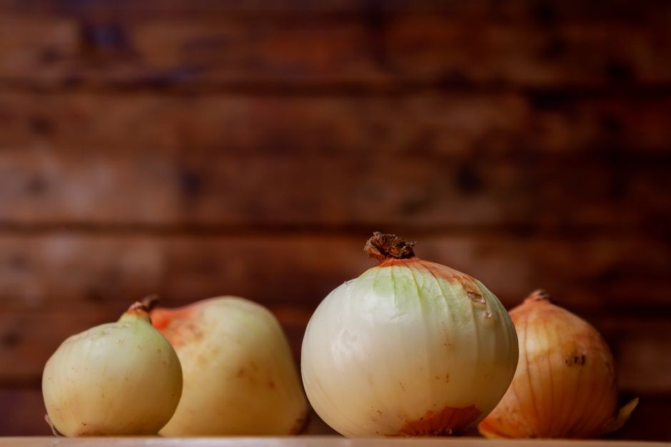Kedekatan bawang putih segar di meja kayu, menciptakan suasana dapur yang rustik.