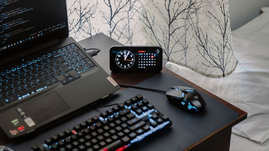 Laptop gaming modern dengan pencahayaan keyboard RGB di atas meja