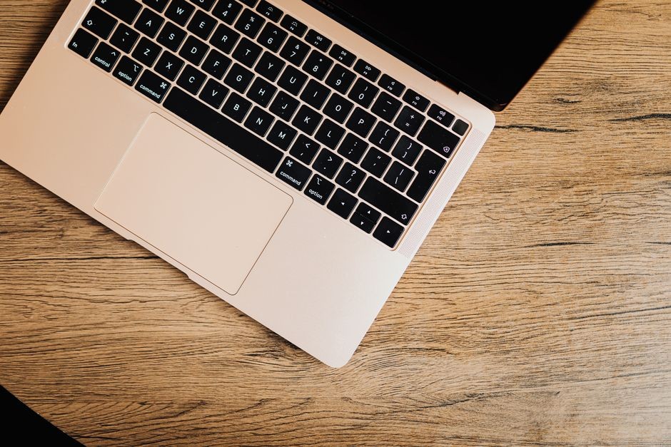 Laptop modern diletakkan rapi di atas meja kerja dalam kondisi tertutup rapat.