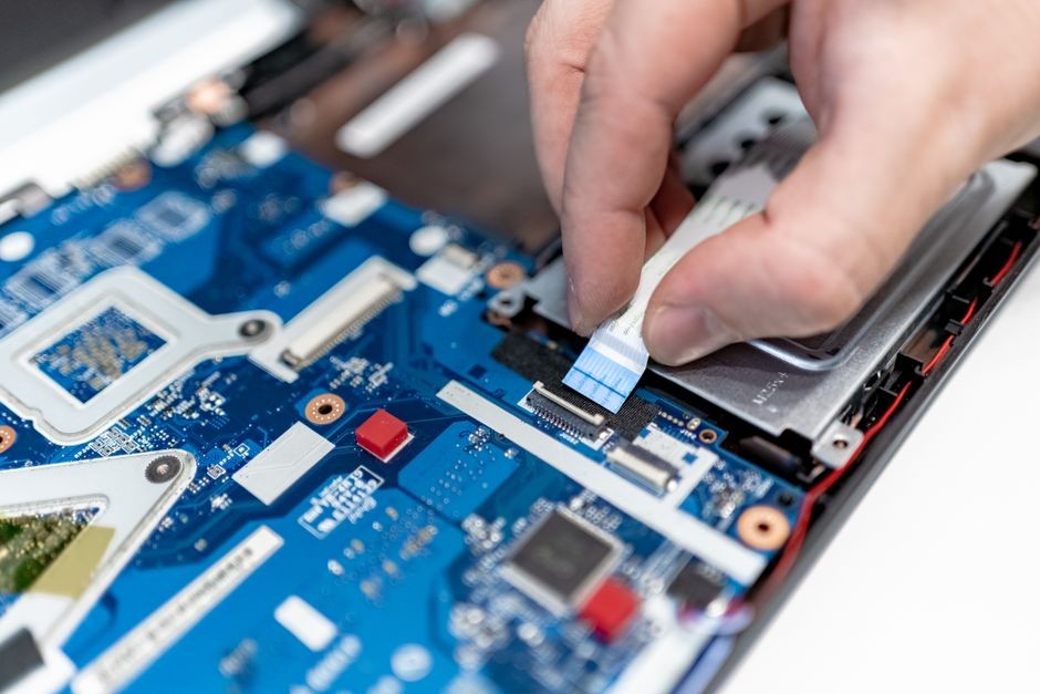 Komponen baterai lithium dan sirkuit motherboard internal pada laptop modern.