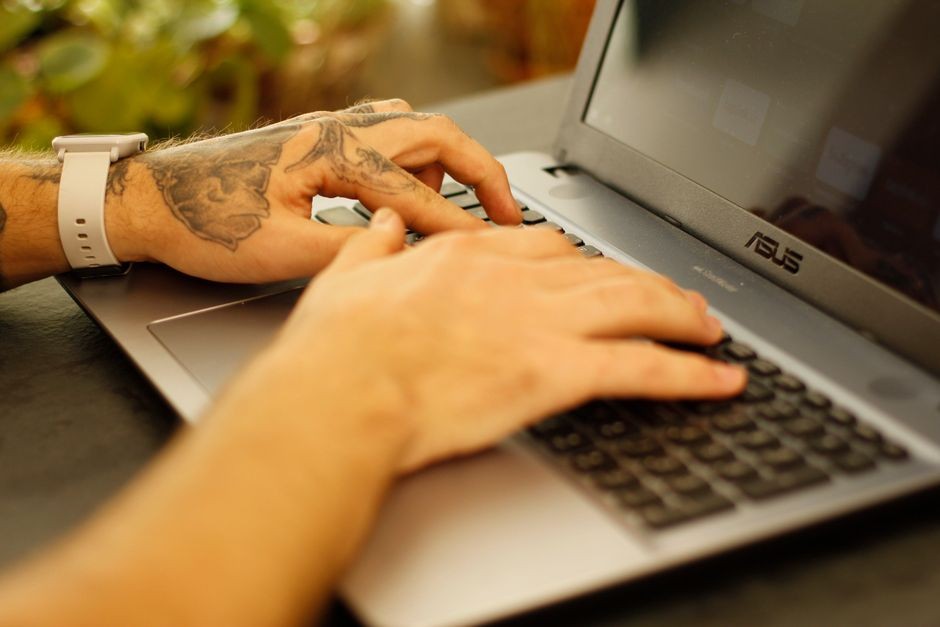 Seseorang sedang mengetik di keyboard laptop membuka setelan sistem operasi.