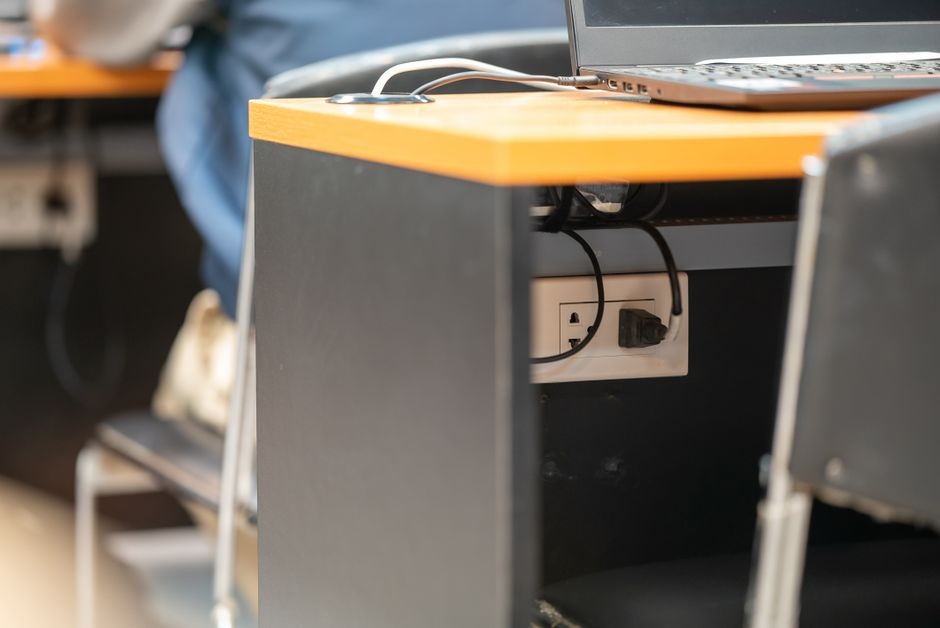Indikator daya colokan kabel charger pada laptop di ruang kerja