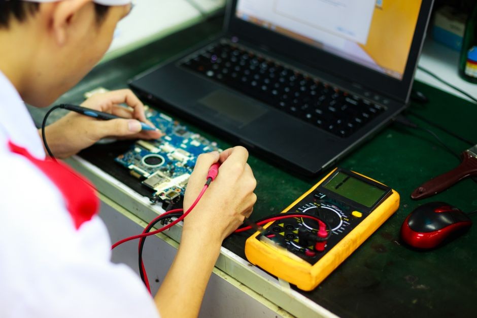 Pengecekan teknis komponen dan perangkat keras laptop di meja kerja