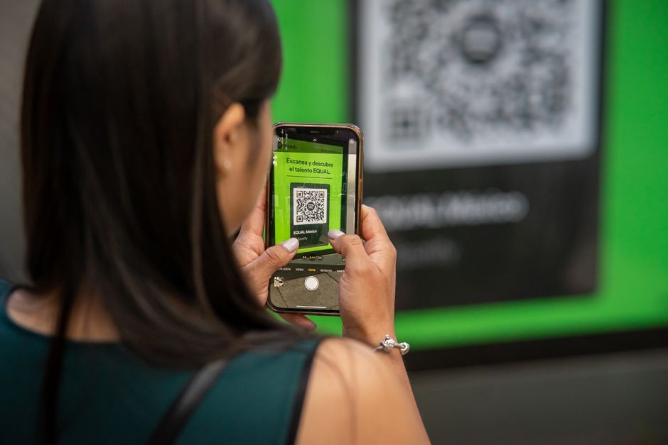 Seorang perempuan menggunakan smartphone-nya untuk memindai kode QR di Mexico City, menangkap teknologi modern dalam aksi.