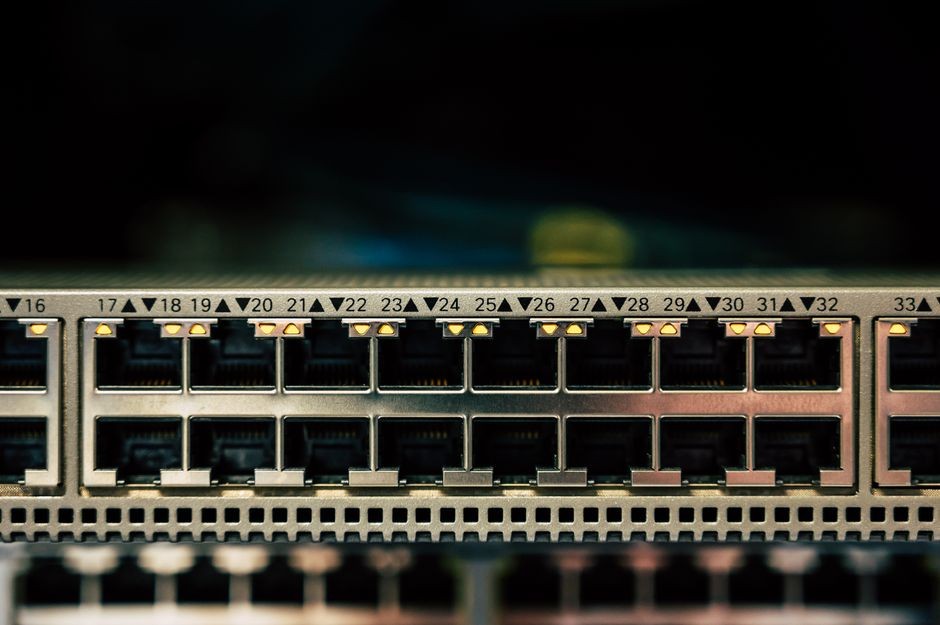 Pandangan detail saklar jaringan yang menampilkan beberapa port Ethernet dan indikator LED.